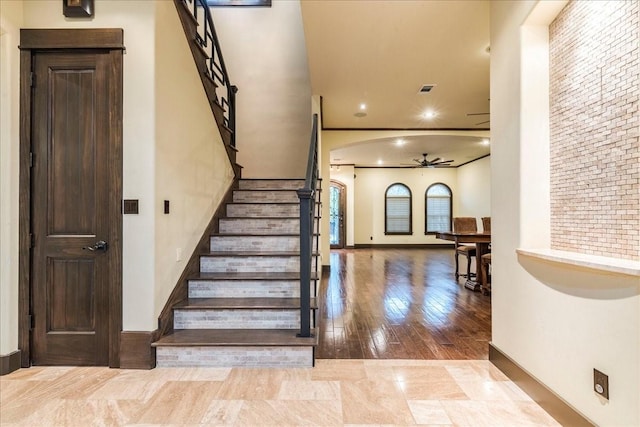 stairway featuring ceiling fan