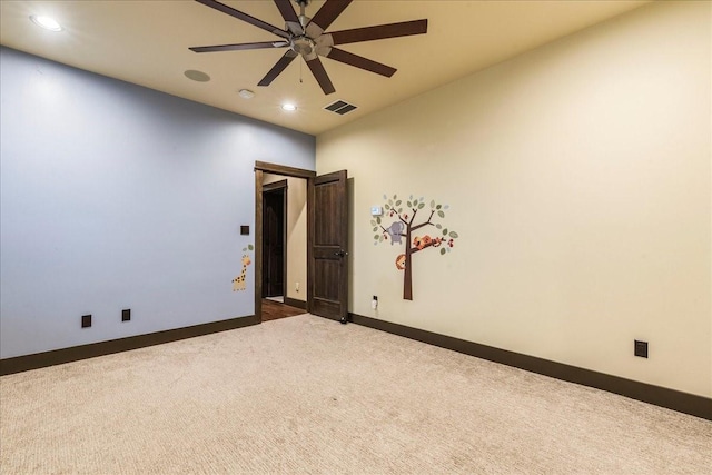 carpeted spare room featuring ceiling fan