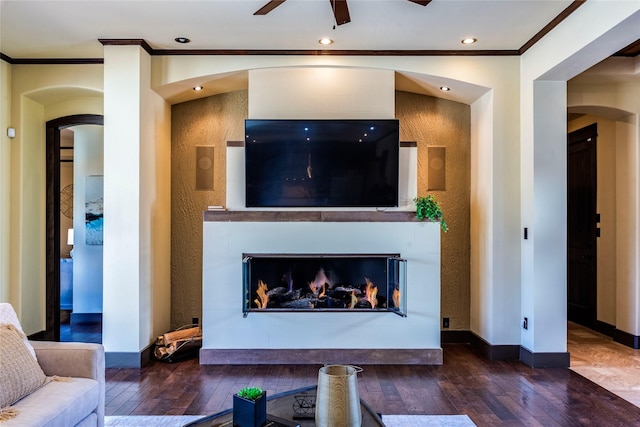 living room with crown molding, dark hardwood / wood-style floors, and ceiling fan