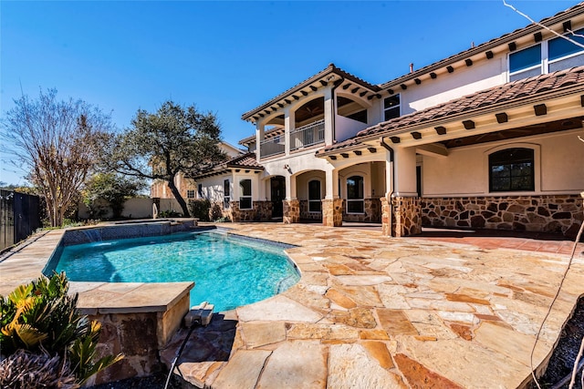 view of swimming pool with pool water feature and a patio