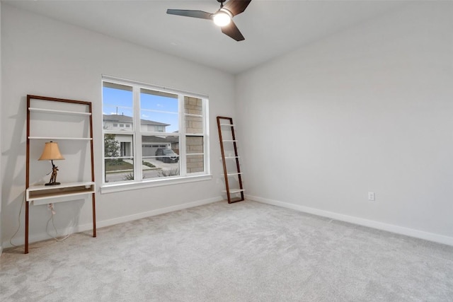 spare room featuring light carpet and ceiling fan