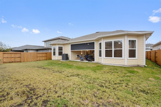 rear view of house with a yard, a patio, and central AC unit