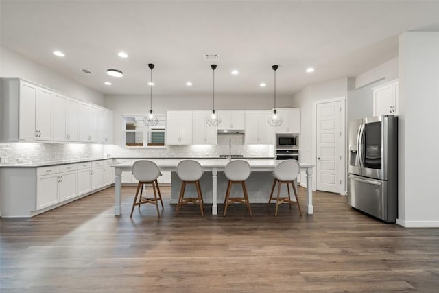 kitchen featuring white cabinets, dark hardwood / wood-style flooring, stainless steel appliances, and a kitchen island with sink