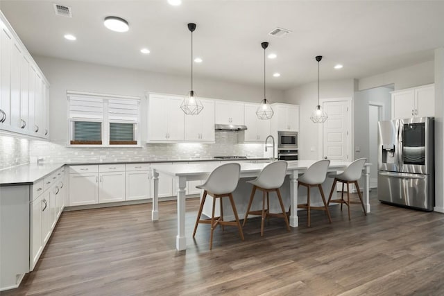 kitchen with hardwood / wood-style floors, white cabinetry, and appliances with stainless steel finishes