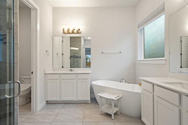 full bathroom with tile patterned floors, vanity, separate shower and tub, and toilet