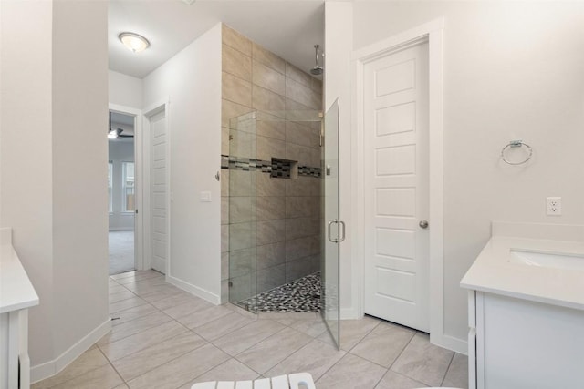 bathroom with tile patterned flooring, vanity, ceiling fan, and walk in shower