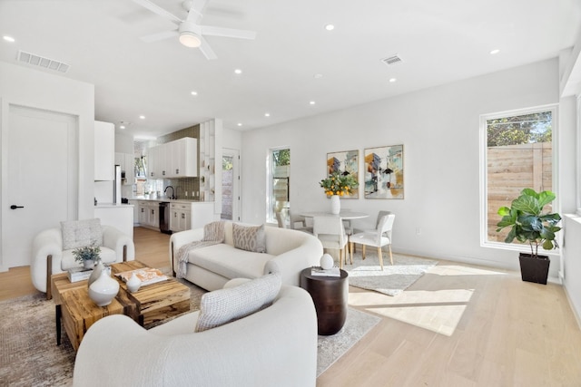 living room with ceiling fan and light hardwood / wood-style floors