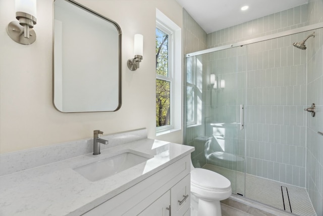 bathroom featuring an enclosed shower, vanity, and toilet