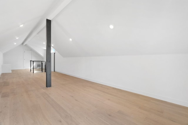 bonus room with vaulted ceiling with beams and light wood-type flooring