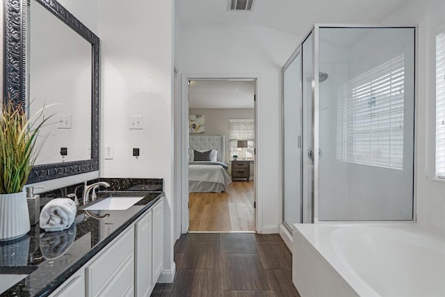 bathroom with hardwood / wood-style floors, vanity, and independent shower and bath