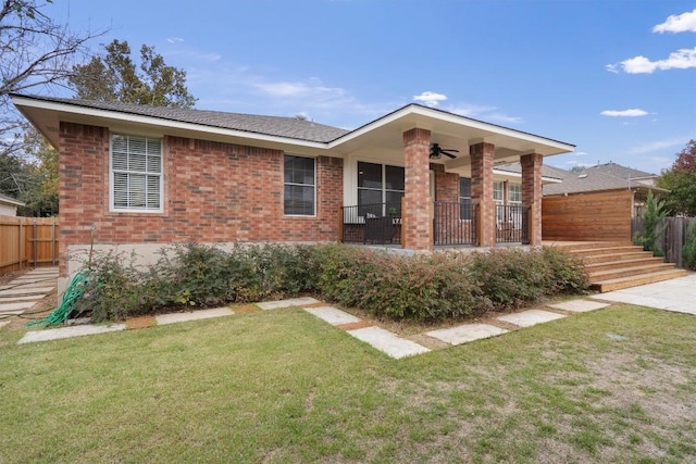 ranch-style home with a front lawn and ceiling fan