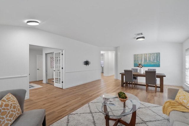 living room featuring vaulted ceiling and light hardwood / wood-style flooring