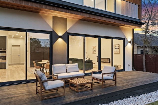 deck at dusk with an outdoor hangout area