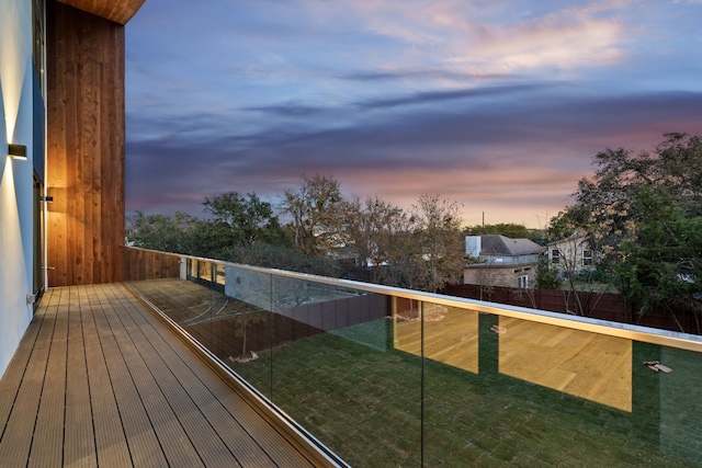 deck at dusk featuring a lawn