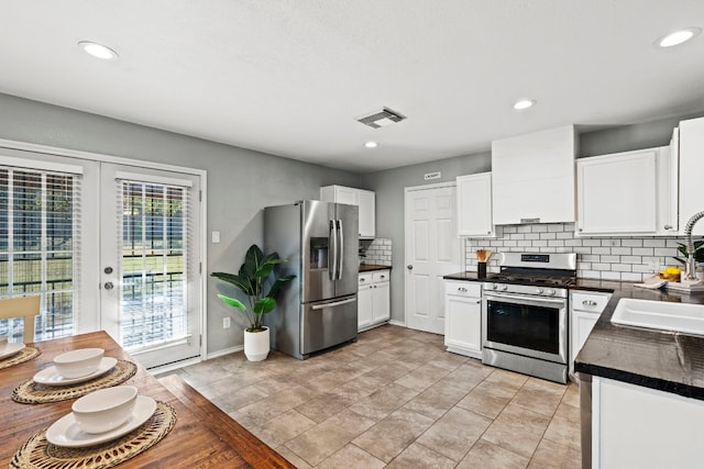 kitchen featuring french doors, backsplash, stainless steel appliances, sink, and white cabinets