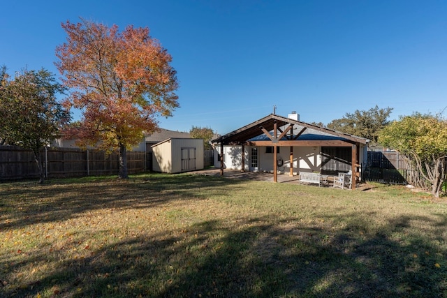 rear view of property featuring a patio, a storage unit, and a lawn