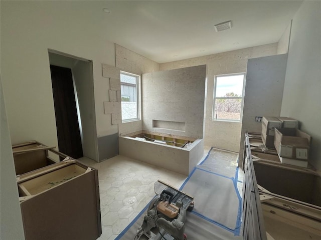 bathroom featuring visible vents, a healthy amount of sunlight, and a bath