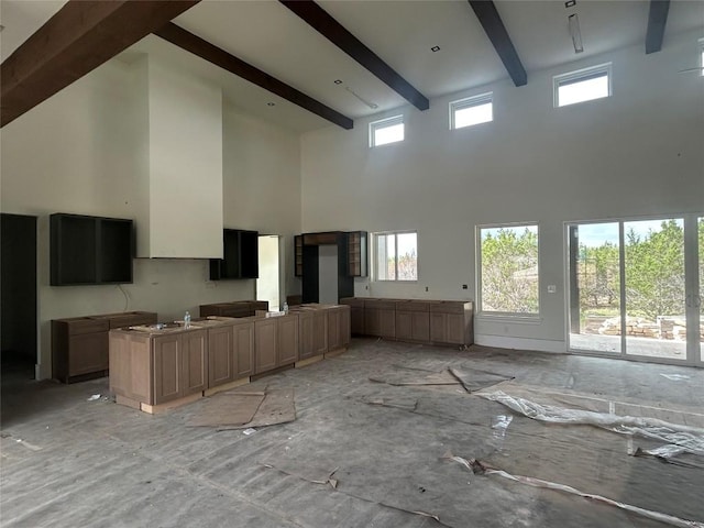 unfurnished living room featuring a high ceiling and beam ceiling