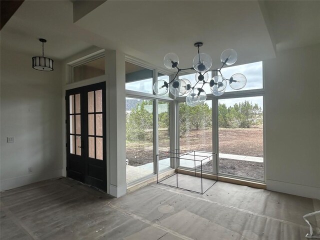 entryway featuring plenty of natural light, baseboards, and a chandelier