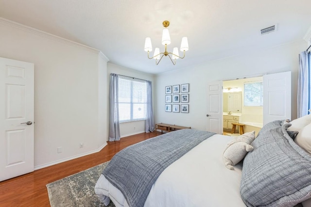 bedroom featuring connected bathroom, crown molding, a chandelier, and hardwood / wood-style flooring