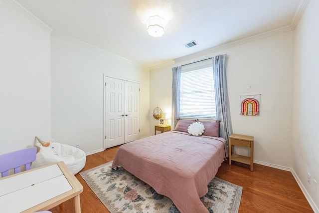 bedroom featuring a closet, ornamental molding, and hardwood / wood-style flooring