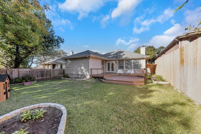 rear view of house with a lawn and a deck