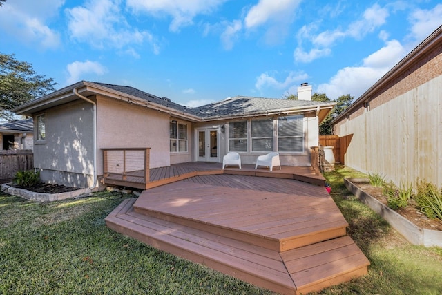 back of house featuring french doors, a deck, and a lawn