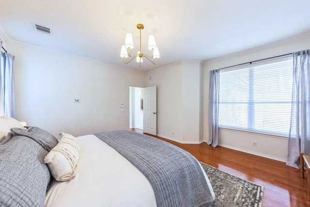 bedroom with hardwood / wood-style floors, an inviting chandelier, and ornamental molding