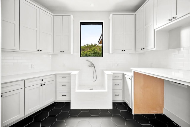 laundry area with dark tile patterned floors