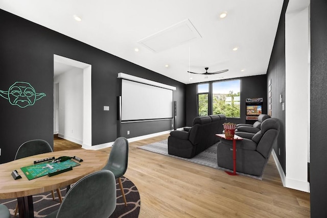 cinema with ceiling fan and light hardwood / wood-style flooring