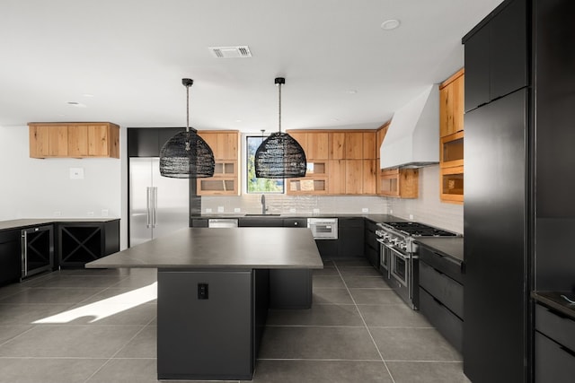 kitchen with custom exhaust hood, hanging light fixtures, a kitchen island, high quality appliances, and sink