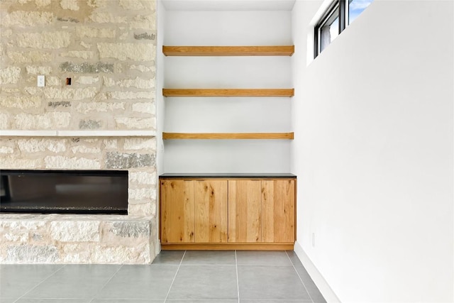 interior space with light tile patterned floors and a fireplace