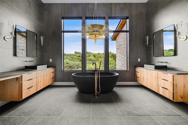 bathroom featuring a bath, tile patterned flooring, wooden walls, and vanity