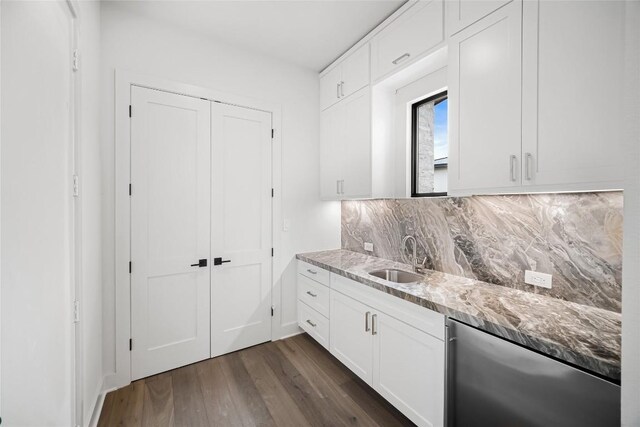 kitchen featuring white cabinets, dark wood-type flooring, sink, backsplash, and light stone counters