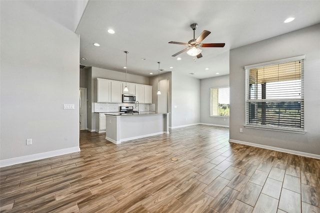 unfurnished living room with light hardwood / wood-style floors and ceiling fan