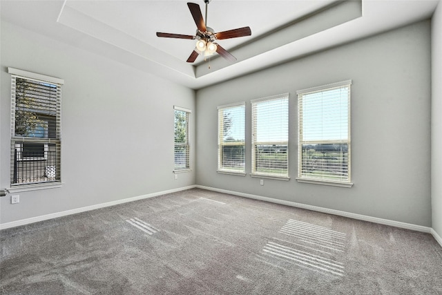 unfurnished room featuring ceiling fan, a raised ceiling, and carpet floors