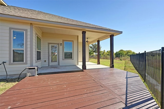 deck with ceiling fan, a patio area, and a lawn