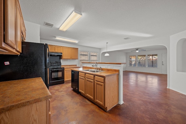 kitchen with decorative light fixtures, ventilation hood, sink, black appliances, and a center island with sink