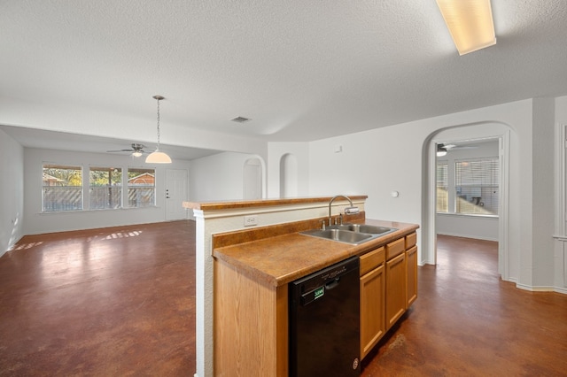 kitchen with pendant lighting, black dishwasher, sink, a kitchen island with sink, and a textured ceiling