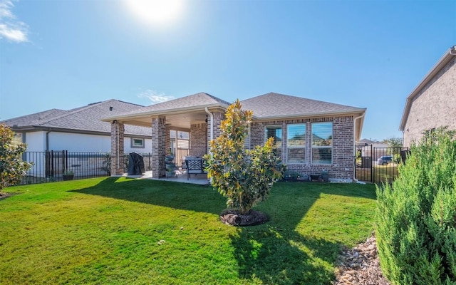 rear view of property with a lawn and a patio