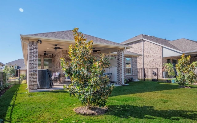 back of house with ceiling fan, a patio, and a lawn