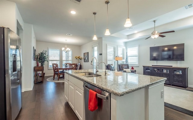 kitchen featuring decorative light fixtures, white cabinetry, an island with sink, sink, and stainless steel appliances