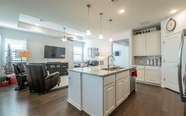 kitchen featuring white cabinetry, sink, pendant lighting, and a raised ceiling