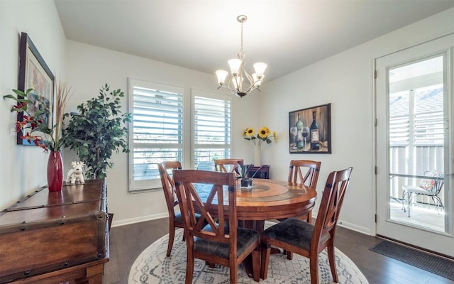 dining space featuring dark hardwood / wood-style flooring and a notable chandelier