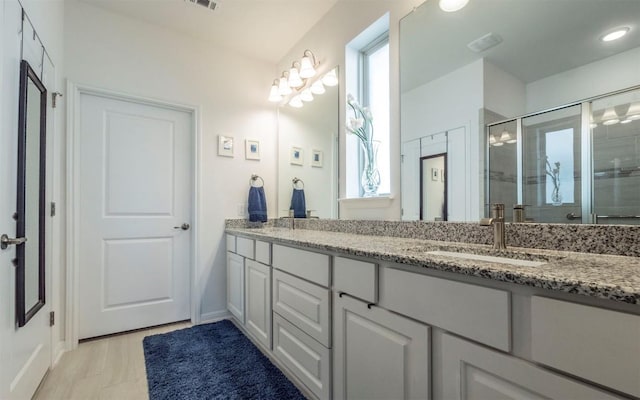 bathroom with vanity and a shower with door