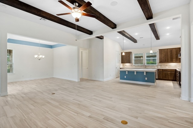 interior space with backsplash, light wood-type flooring, beam ceiling, decorative light fixtures, and a kitchen island