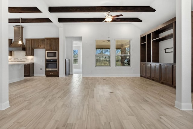 unfurnished living room with beam ceiling, light wood-style flooring, a ceiling fan, and baseboards