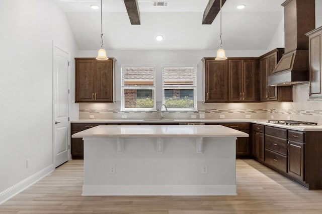 5152 Cornetto Blfs, Round Rock, TX 78665 - kitchen featuring stainless steel gas cooktop, light countertops, light wood-style flooring, a kitchen island, and backsplash