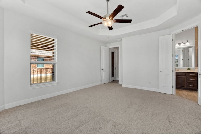 5152 Cornetto Blfs, Round Rock, TX 78665 - unfurnished bedroom with a raised ceiling, light colored carpet, baseboards, and ensuite bathroom