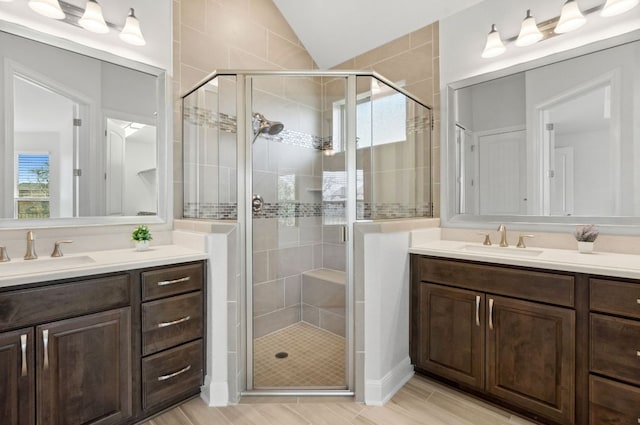 5152 Cornetto Blfs, Round Rock, TX 78665 - bathroom featuring two vanities, lofted ceiling, a stall shower, and wood finished floors